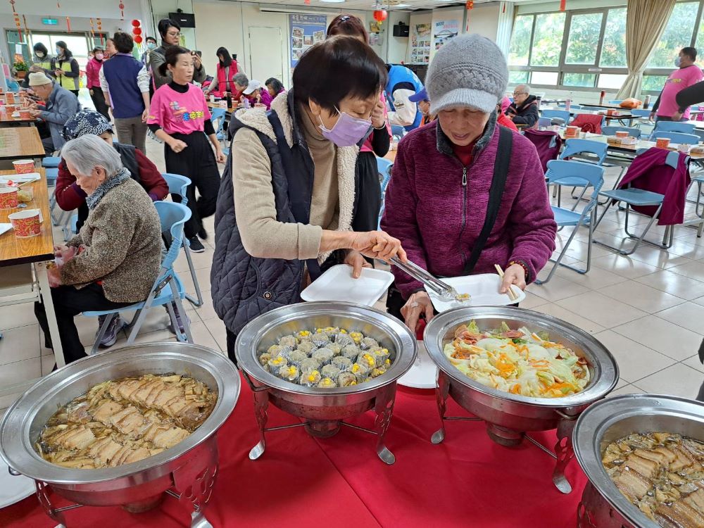 《圖說》永和區民權社區照顧關懷據點團拜共餐中，長輩相互夾菜彼此照顧。〈社會局提供〉