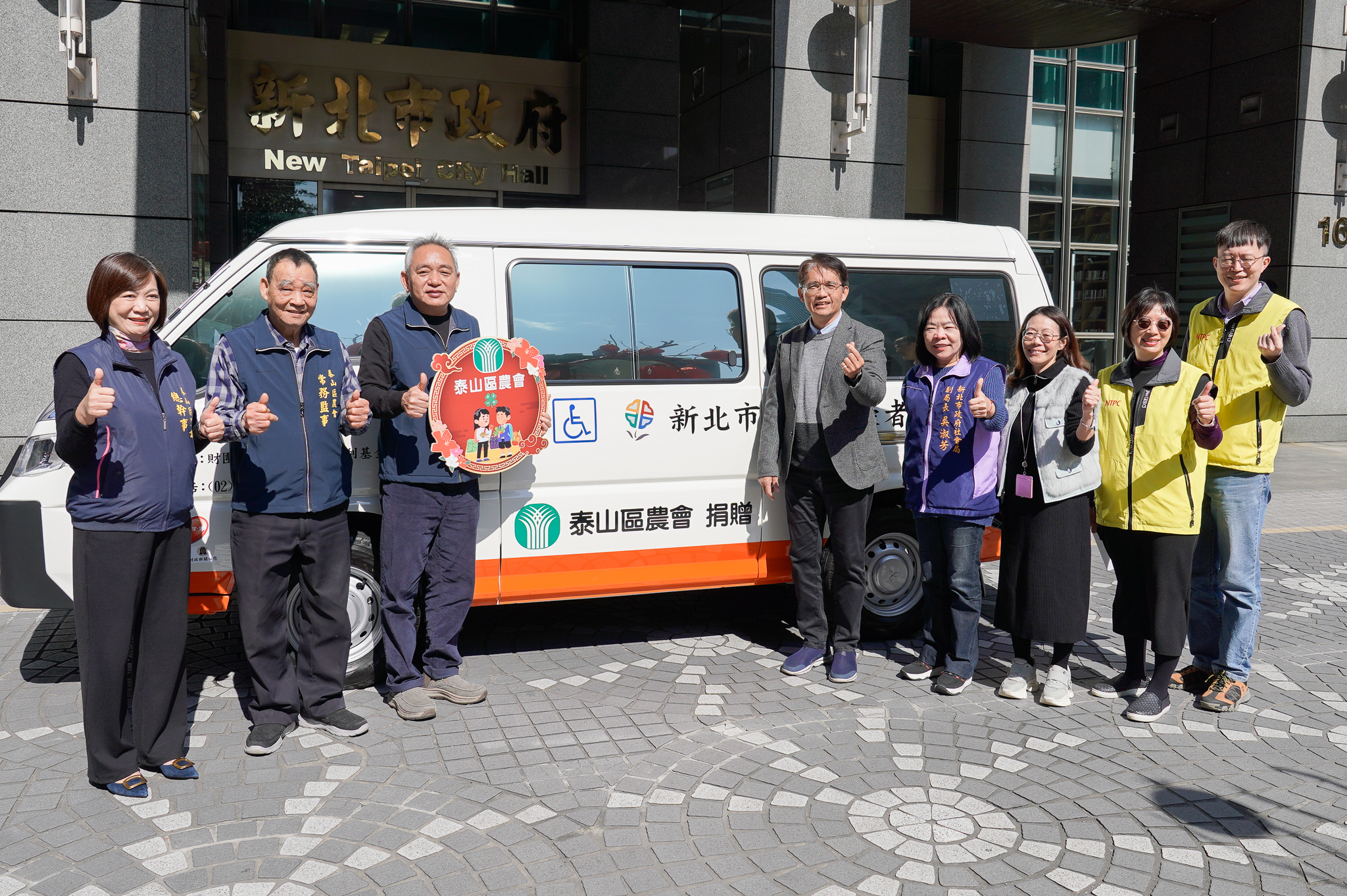 《圖說》新北市泰山區農會將盈餘回饋在地，今日由農會理事長謝文雄(左3)帶領常務監事陳和明(左2)及總幹事李愛娟(左1)，捐贈新北市復康巴士，嘉惠在地市民。〈社會局提供〉