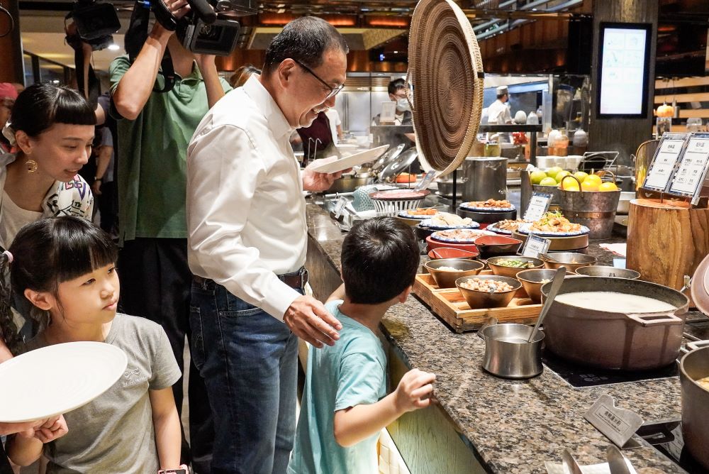 饗食天堂攜手新北公益餐會 百位〈小衛星〉啖佳餚 1 《圖說》侯友宜市長陪著孩子們前往餐食區夾菜。〈社會局提供〉