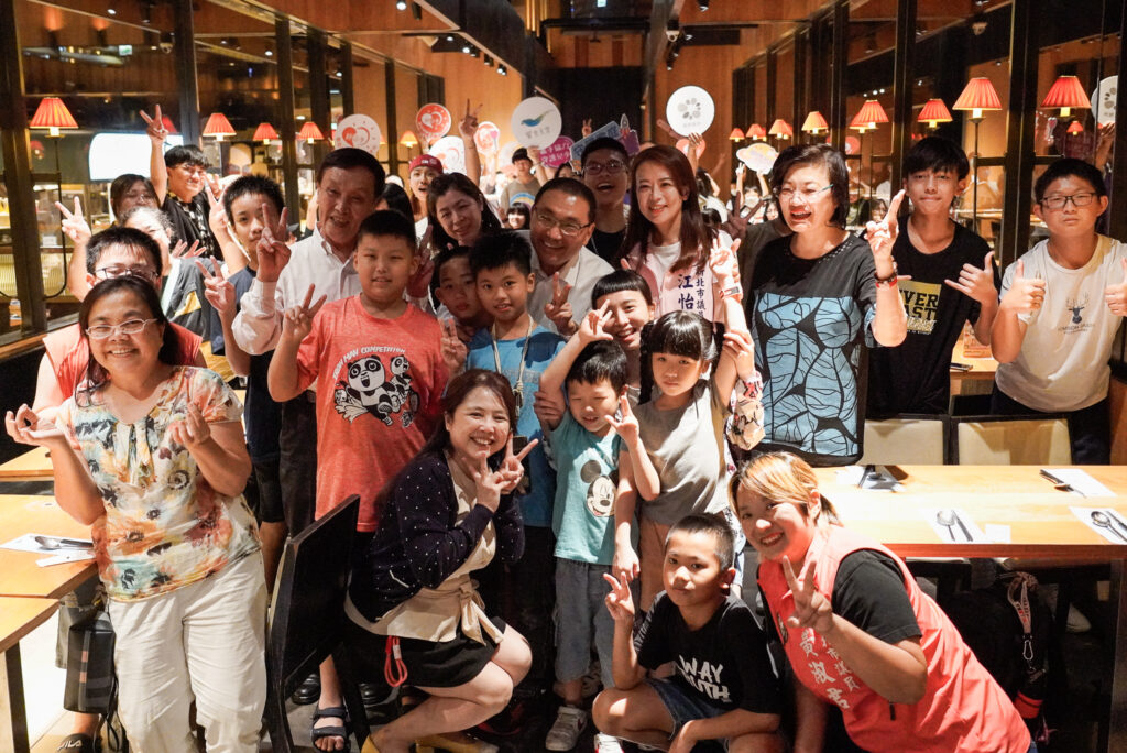 饗食天堂攜手新北社會局舉辦公益餐會，邀百位小衛星兒少用餐。新北市長侯友宜驚喜現身，和議員江怡臻、社會局長李美珍等人，與小衛星兒少、照顧者們開心合影