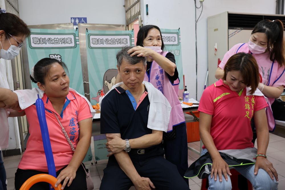 《圖說》勞工局長陳瑞嘉、永盛里長侯錦足及培德里長盧姿貝，在職訓學員的熱情邀請下，親身體驗肩頸按摩。〈勞工局提供〉