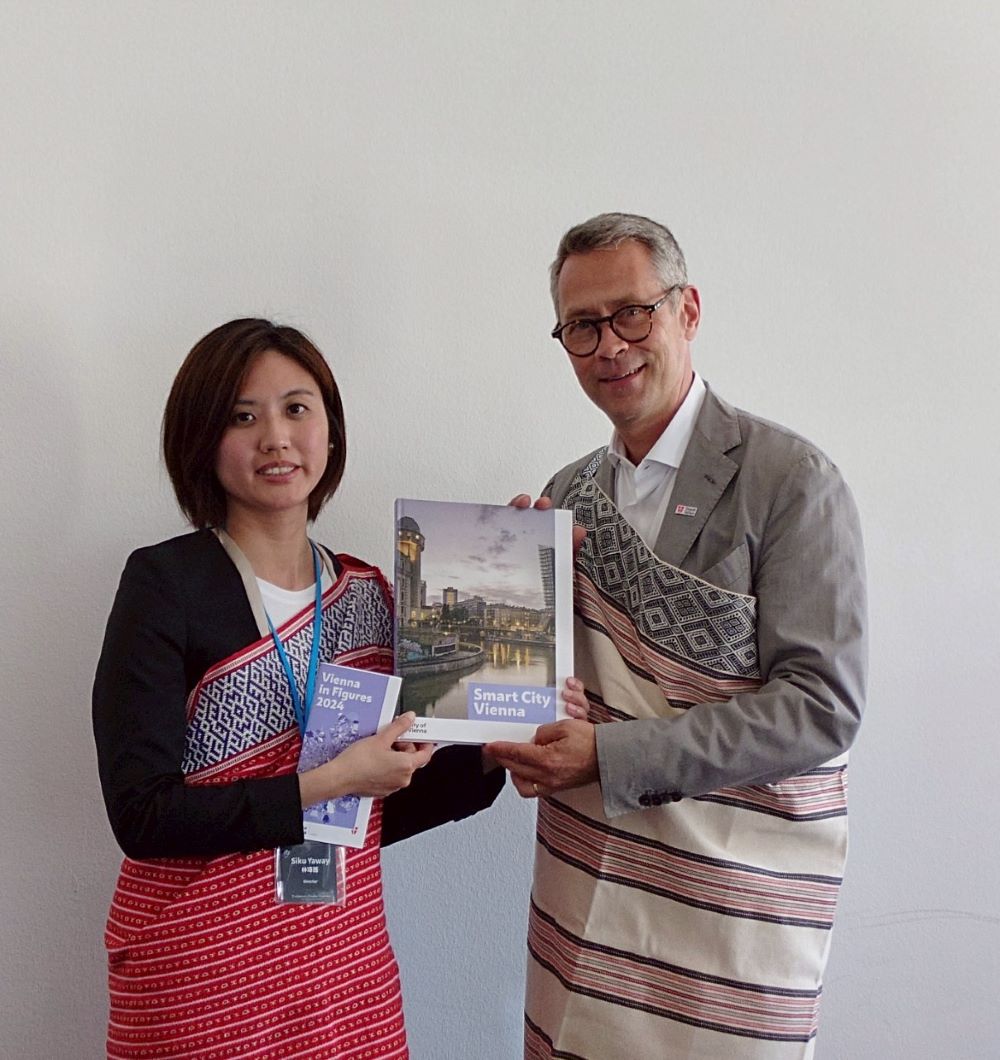 臺奧里程碑! 新北與維也納世博館簽合作備忘錄 2 《圖說》維也納市政府文化部副處長Daniel Löcker(右)致贈書籍予新北市原民局長林瑋茜(左),新北市原民局也回贈烏來在地工坊製作之披肩予副處長。〈原民局提供〉