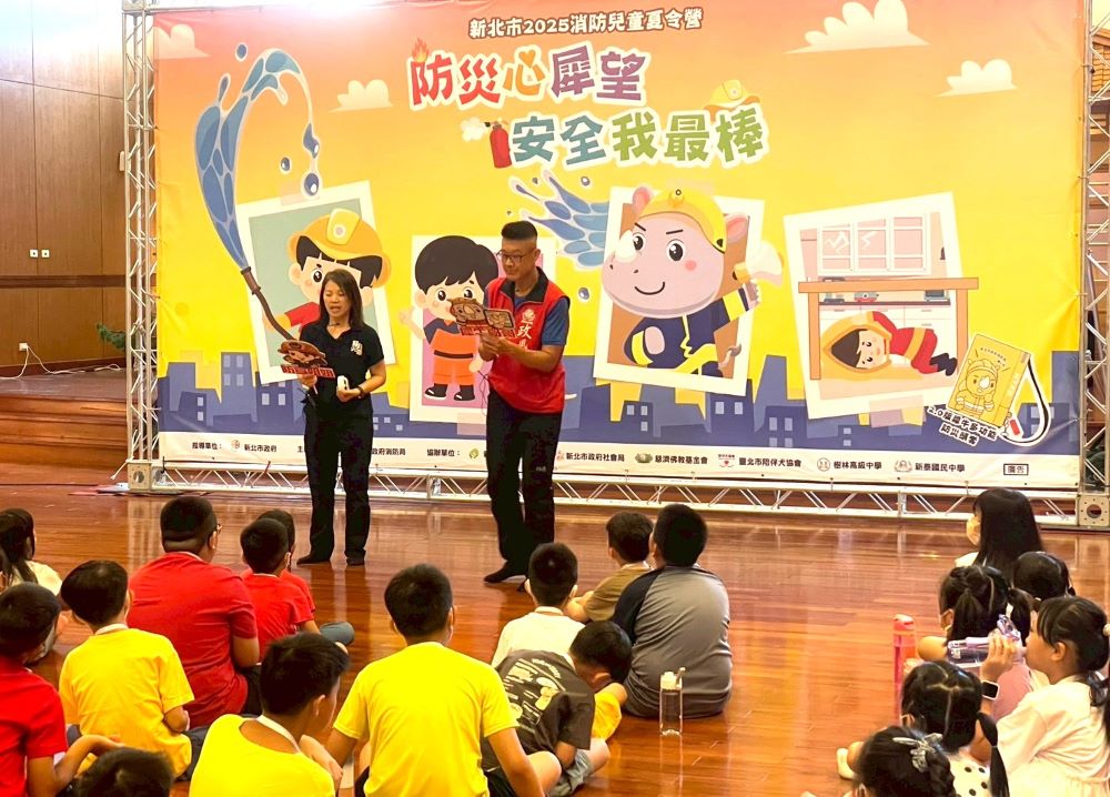 《圖說》每年於暑假舉辦的「新北消防兒童夏令營」活動深獲好評，政風室林三龍主任〈右〉與小朋友進行趣味競賽。〈政風室提供〉