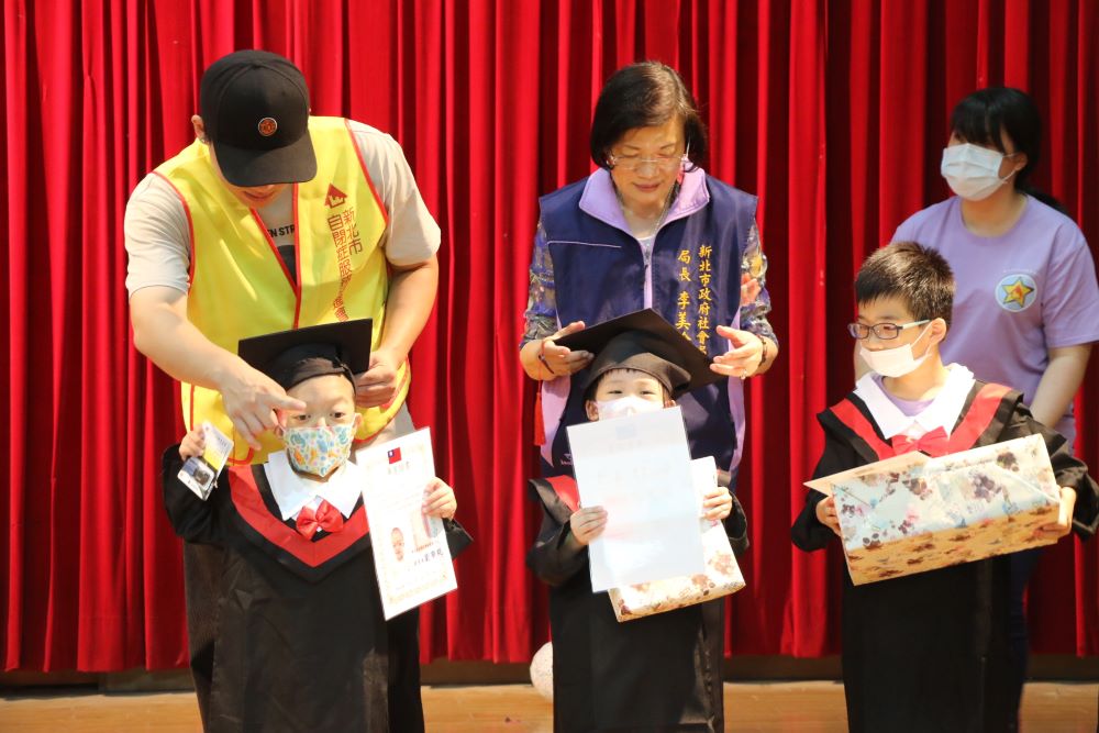 《圖說》新北市社會局長李美珍為結業的星兒戴上小方帽。〈社會局提供〉