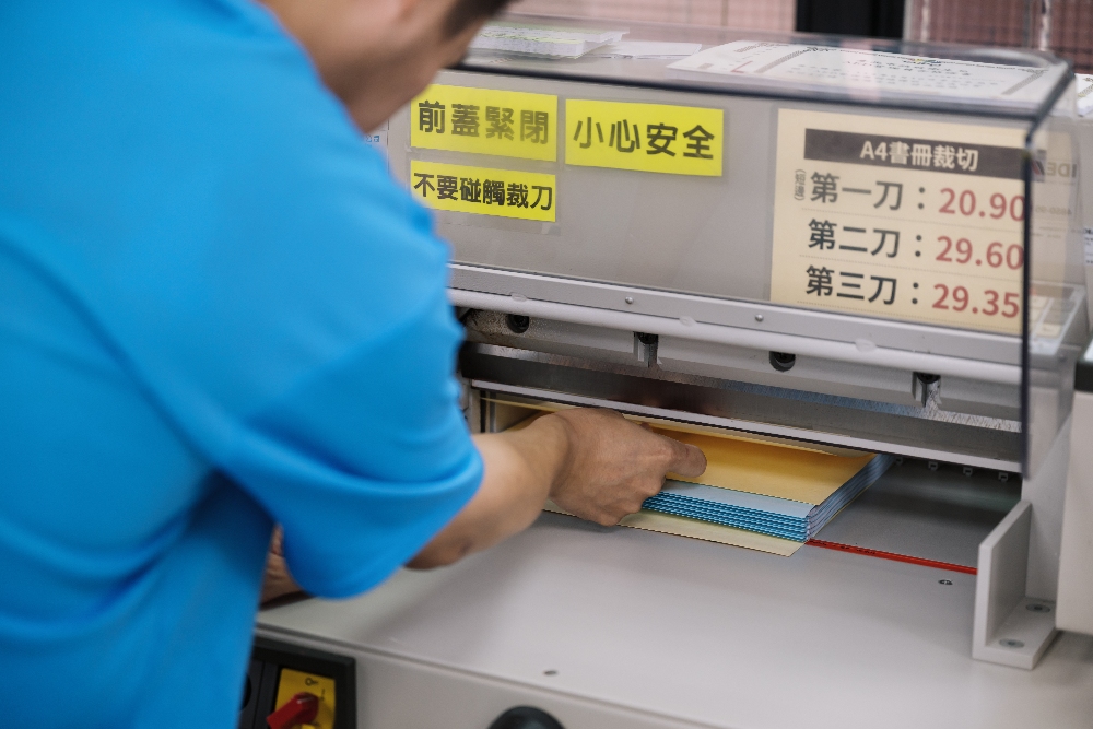 以責任為筆 以堅持為墨:賴昱全寫下職場十年誌 3 ▲昱全用手指確認每張紙都有對齊。(圖/庇護工場提供)