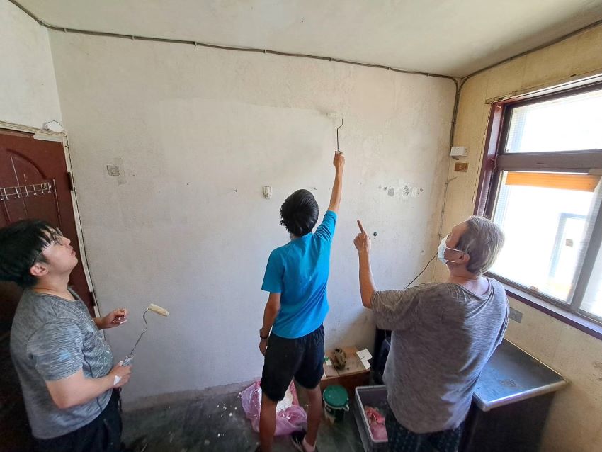 《圖說》新北市少年培力園培力的「小傑」（中），幫忙街友「阿哲」住處粉刷牆壁。〈社會局提供〉