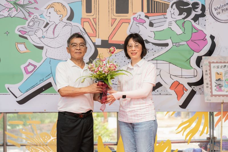 《圖說》紫東社區發展協會李明宏理事長(左)致贈豔紅鹿子百合予新北市政府農業局。〈農業局提供〉