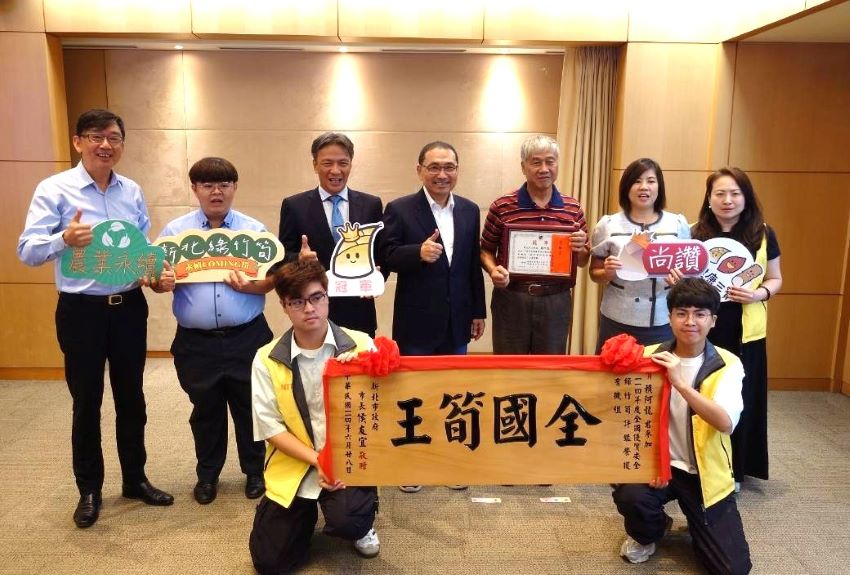 《圖說》三峽區農友賴阿龍(右3)獲全國優質安全綠竹筍驗證評鑑「有機組」冠軍，今日於市政會議獻獎予市長，左一農業局長諶錫輝。〈農業局提供〉