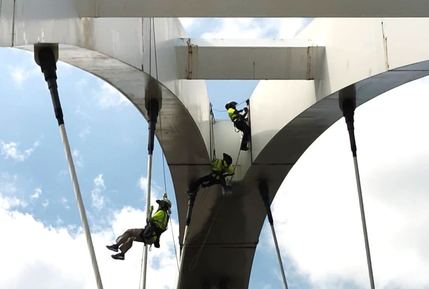 《圖說》高空作業人員以懸吊方式進行新月橋銲道改善作業。〈高灘處提供〉